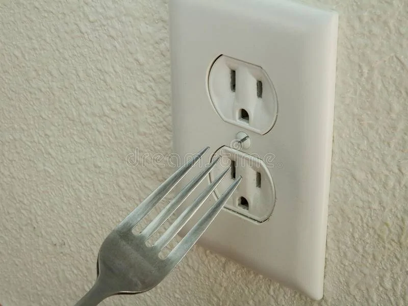 fork-doesn-t-go-outlet-kid-trying-to-put-metal-electrical-63560906.webp